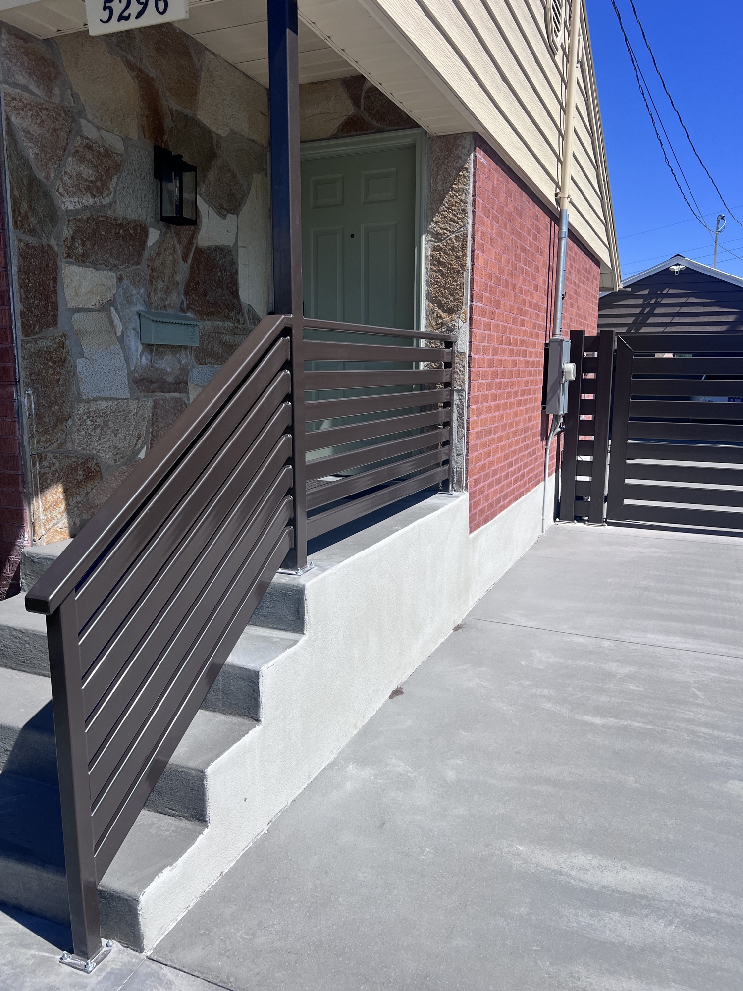 Modern horizontal steel railing and entry gate installed