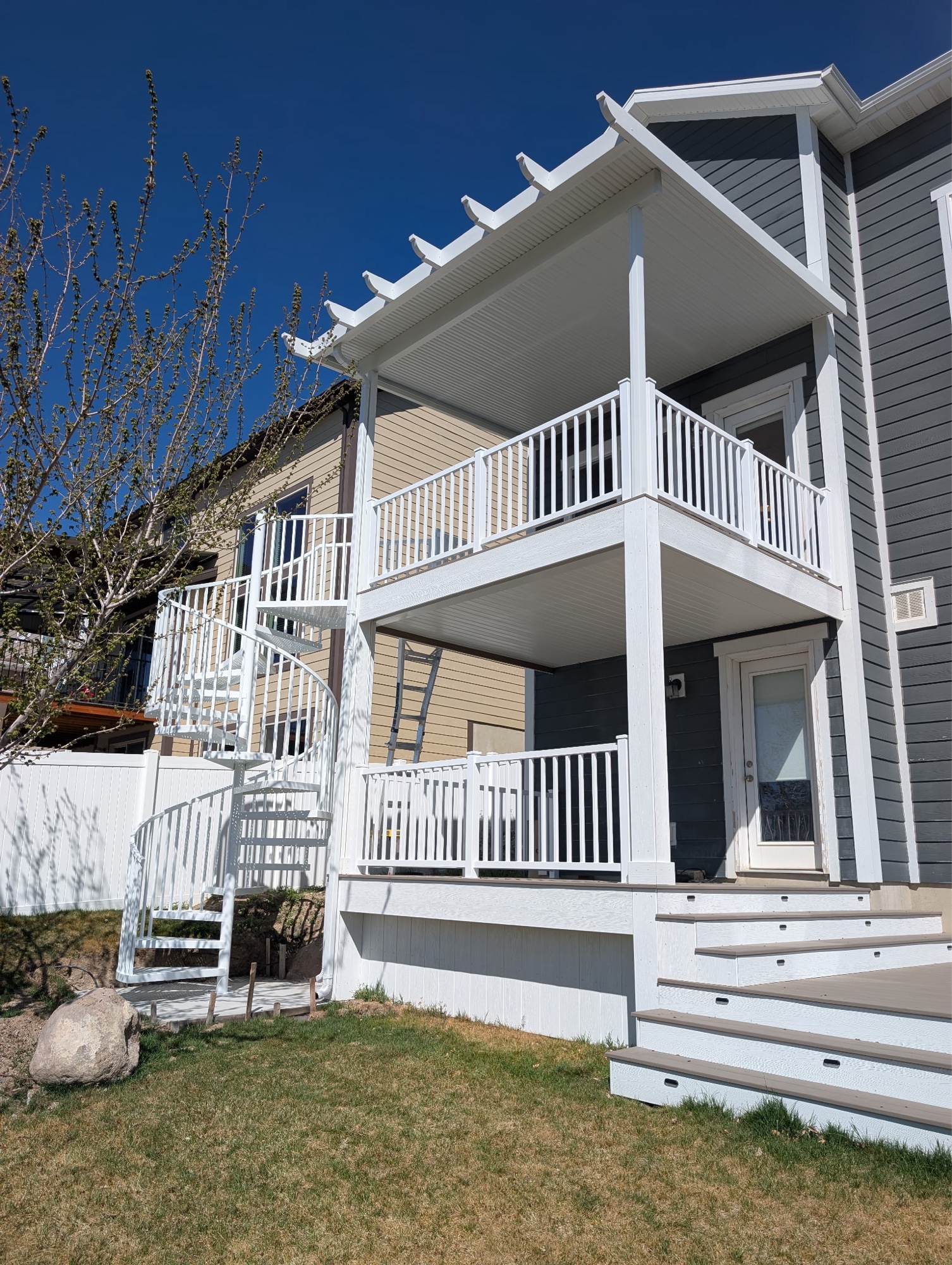 White spiral staircase and deck railings — residential installation by Fitzy's Metals